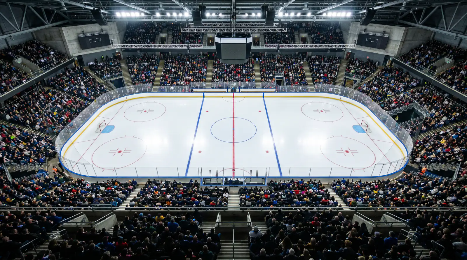 Aerial view of an ice hockey rink during a live match, crowd filling the stands